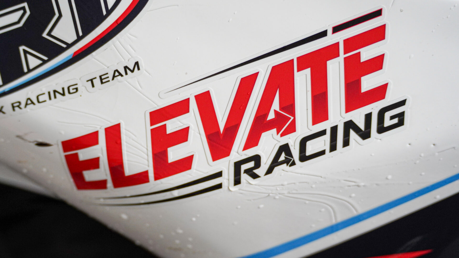 Apex Racing Team and Elevate Racing branding on a rain-speckled race bike fairing.