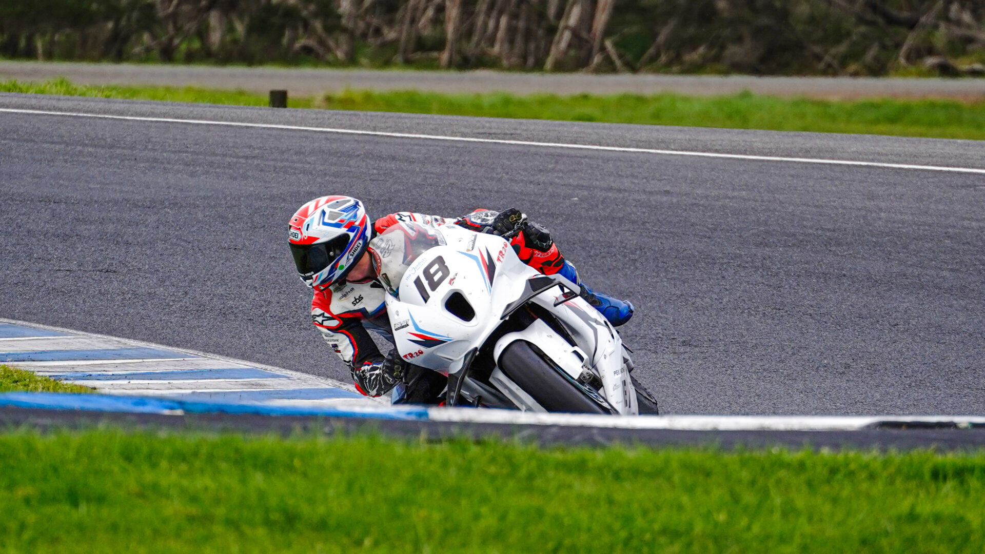 Apex Racing Team rider leaning the number 18 race bike through a corner at Phillip Island.